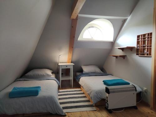 two beds in a attic room with a window at Ferienkate Kap Eiderstedt in Westerhever