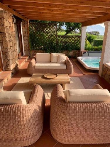 a patio with couches and a table and a pool at Villa Caterina in Monte Petrosu