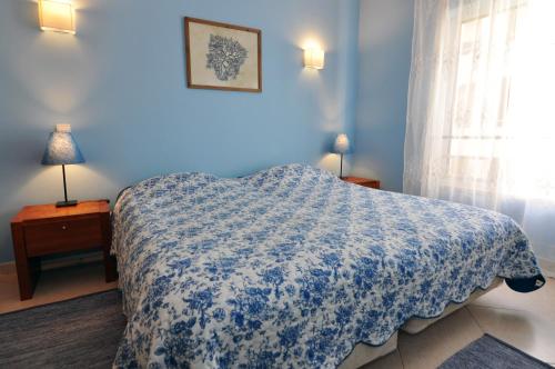 een blauwe slaapkamer met een bed en een raam bij SweetHome at Vila da Praia in Alvor