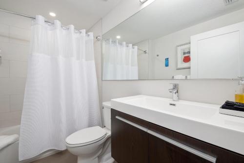 a white bathroom with a toilet and a sink at Escape Coastal Resort on Casey Key in Nokomis