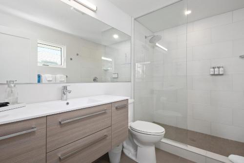 La salle de bains blanche est pourvue de toilettes et d'un lavabo. dans l'établissement Escape Casey Key, à Nokomis