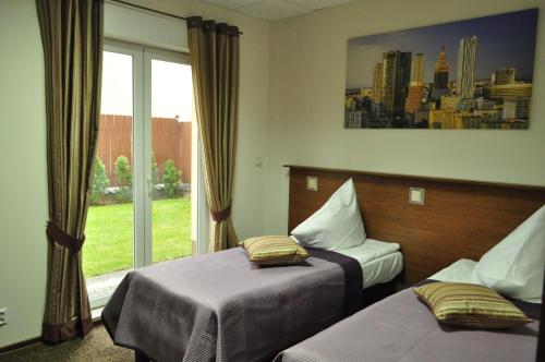 a hotel room with two beds and a window at Villa B&B nocleg przy Centrum Zdrowia Dziecka - Warszawa Międzylesie Wawer blisko CZD in Warsaw