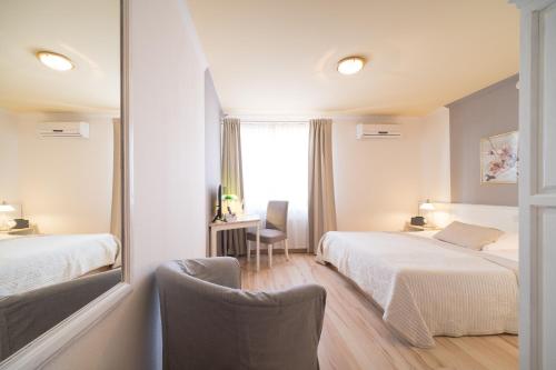 um quarto de hotel com duas camas e um espelho em Hotel Toskana em Wiesbaden