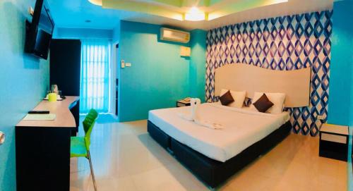a bedroom with a large bed with a desk and a sink at Better Place Hotel in Ubon Ratchathani