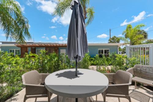 a white table with an umbrella on a patio at Escape Coastal Resort on Casey Key in Nokomis
