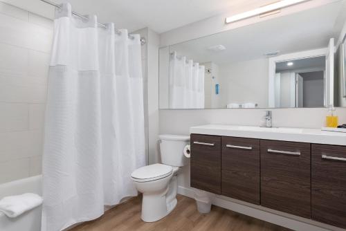 a white bathroom with a toilet and a sink at Escape Coastal Resort on Casey Key in Nokomis