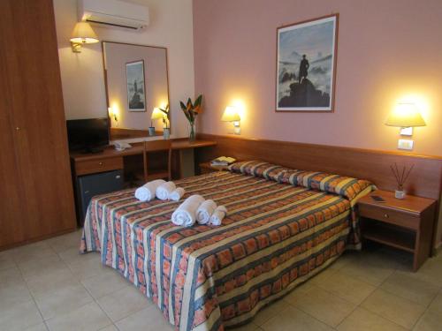 a hotel room with a bed with towels on it at Hotel Palme Gemelle in Vieste