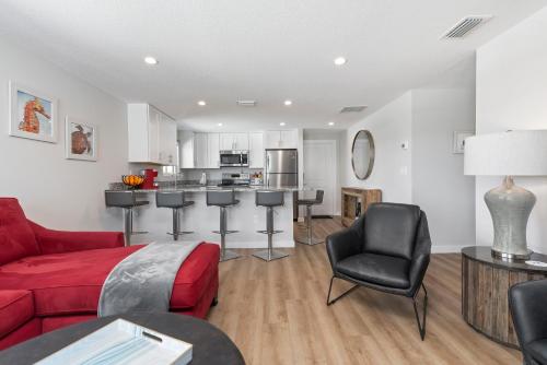 a living room with a red couch and a kitchen at Escape Coastal Resort on Casey Key in Nokomis