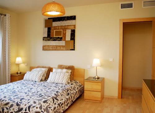 a bedroom with a bed and two lamps on a dresser at MalagadeVacaciones - Pacifico 18 in Málaga