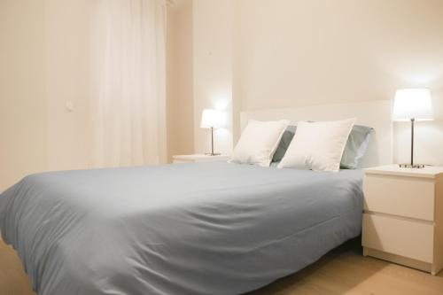 マラガにあるMalagadeVacaciones - Azuagaのベッドルーム(白い大型ベッド、ランプ2つ付)