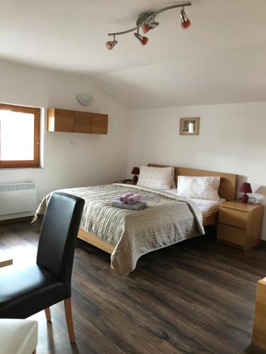 a bedroom with a large bed and a chair at Penzion Marie - Žumberk in Žumberk