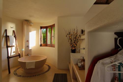 a bathroom with a large tub in the corner of a room at Zoa Hotel in Mazunte