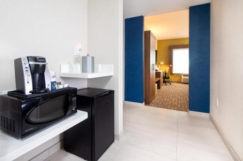 a room with a television and a living room at Holiday Inn Express & Suites Halifax Airport by IHG in Enfield