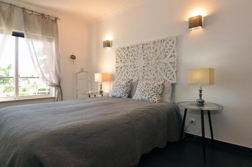 een slaapkamer met een groot bed en een raam bij Sea and Pool at Vila da Praia in Alvor