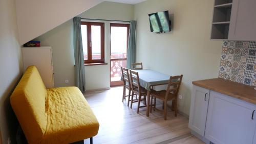 a kitchen and dining room with a table and chairs at Apartament Hanka in Krościenko