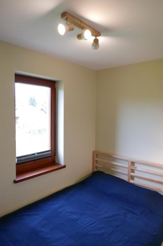 a bedroom with a large blue bed and a window at Apartament Hanka in Krościenko