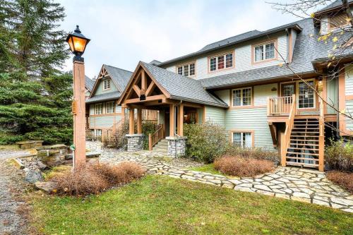 a large house with a porch and a street light at Les Falaises Tremblant - Ski Inout Condo W2bdrs in Mont-Tremblant