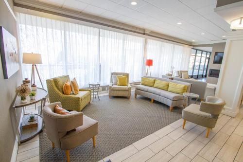 a living room with couches and chairs in a room at Holiday Inn Bloomington Airport South-Mall Area by IHG in Bloomington