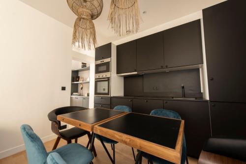 - une cuisine avec une table et des chaises bleues dans l'établissement Arigato, à Paris