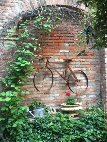 una bicicletta è attaccata a un muro di mattoni di La Casa sul Giardino- GARDEN HOUSE a Novi Ligure