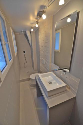 une salle de bain blanche avec un lavabo et un miroir dans l'établissement Bourbons, à Paris
