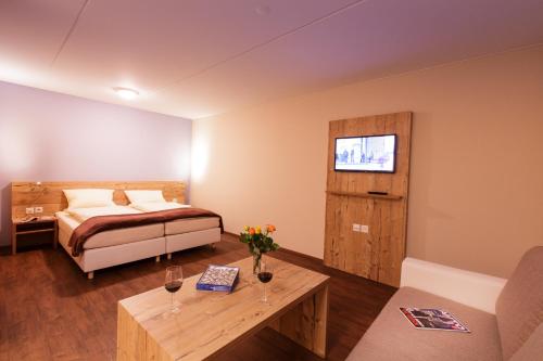 ein Schlafzimmer mit einem Bett, einem Tisch und einem Sofa in der Unterkunft Wohntel - wohnen wie im Hotel in Sevelen