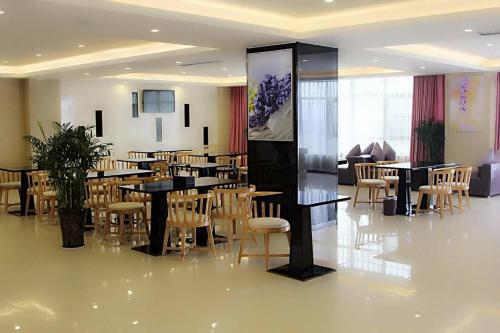 a restaurant with tables and chairs in a room at Lavande Hotel Zhengzhou Economic Zone International Logistics Park in Zhengzhou