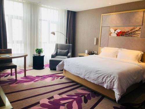 a bedroom with a bed and a desk and a chair at Lavande Hotel Zhengzhou Economic Zone International Logistics Park in Zhengzhou