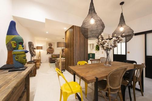 une salle à manger avec une table en bois et des chaises jaunes dans l'établissement Out of Africa, à Paris