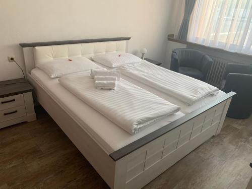 a large white bed with two white towels on it at Hotel Brauhaus zur Krone in Bergheim