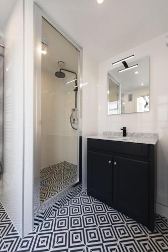 une salle de bain avec une douche, un lavabo et un miroir dans l'établissement Voyageur sans bagage, à Paris