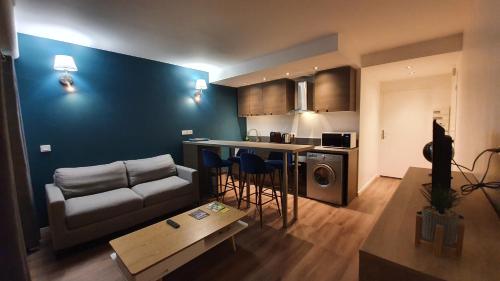 Una sala de estar con un sofá y una cocina. en Le nid douillet d'Angèlique et David avec Parking, en Rambouillet