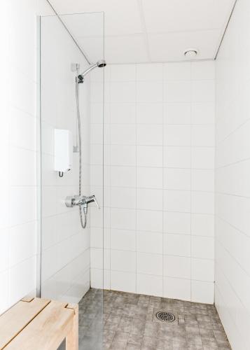a bathroom with a shower with white tiles at Sky Hostel Helsinki in Helsinki