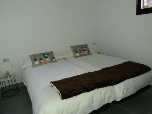 1 dormitorio con 1 cama blanca grande y 3 almohadas en Casa El Mirador, en Fuencaliente de la Palma
