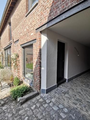a brick building with a garage with a door at Elingenhof in Elingen