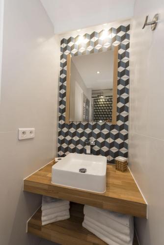 une salle de bain avec un lavabo et un miroir dans l'établissement Magnum, à Paris