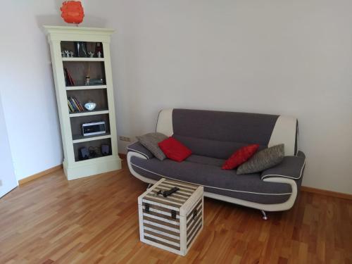 sala de estar con sofá gris y almohadas rojas en GL Single Town Apartment en Wiesbaden