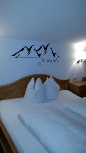 a bedroom with a bed with a sign on the wall at Haus Theresia in Alpbach