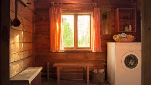 a kitchen with a window and a washing machine at Grande Tiidu Sauna House in Rõuge