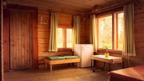 a kitchen with a refrigerator and a table in a cabin at Grande Tiidu Sauna House in Rõuge