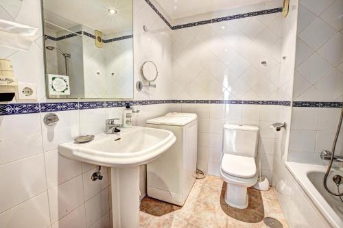 a white bathroom with a sink and a toilet at Beachfront Parque Paloma in Benalmádena