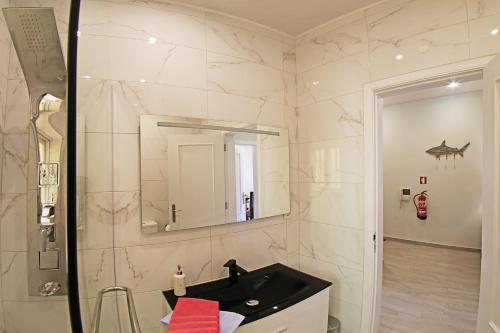 a bathroom with a black sink and a mirror at Few Steps to the Beach in Alvor