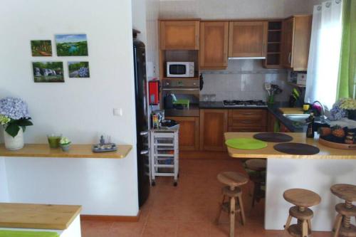a kitchen with wooden cabinets and a counter top at Hilltop Azores - Beach & Countryside in Porto Formoso