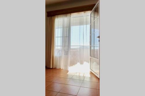 Habitación con ventana y suelo de baldosa. en Hilltop Azores - Beach & Countryside, en Porto Formoso