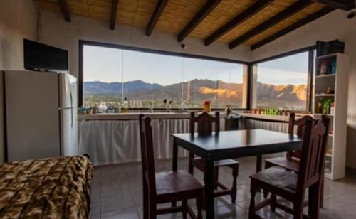 a kitchen with a table and chairs and a large window at Cabaña Abra Del Monte in Cachí