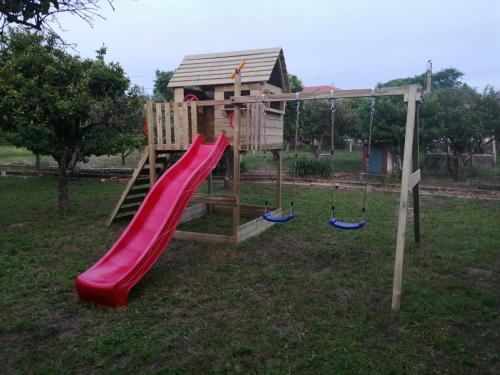 un parco giochi con scivolo e una casetta per i giochi di Casa das Laranjeiras e parque infantil a Villa Nogueira