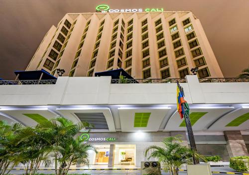 un gran edificio con una bandera delante de él en Hotel Cosmos Cali, en Cali