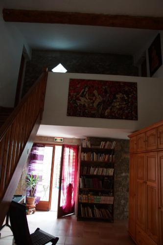 une chambre avec un escalier et une étagère avec des livres dans l'établissement Chambres d´Hôtes Prieuré d'Orniols, à Goudargues