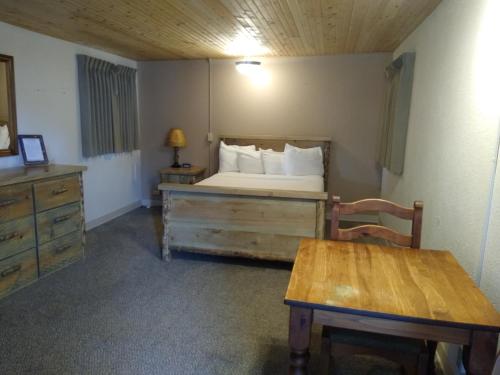a bedroom with a bed and a table in a room at Townhouse Motel in Lusk