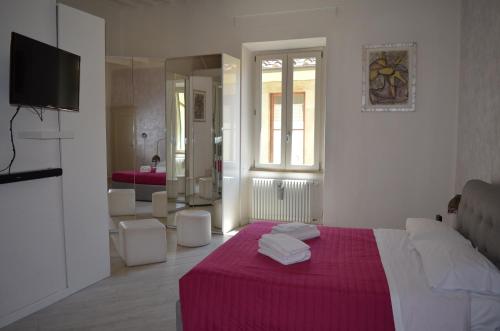 a bedroom with a bed with a red blanket and a bathroom at Allegra Toscana - Affittacamere Guest house Arezzo in Arezzo